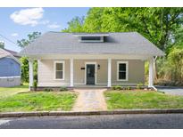 Charming home featuring a covered porch with white columns and a landscaped front yard at 1010 Cobb St, Durham, NC 27707