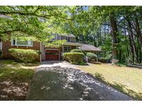 Charming home featuring a red garage door, brick accents, and a well-manicured front yard at 1015 Boathouse Ct, Raleigh, NC 27615