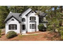 Charming white brick home featuring black accents and mature landscaping at 106 Windstream Way, Cary, NC 27518