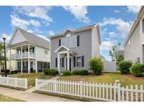 Two-story home with gray siding, black shutters, tidy landscaping and charming white picket fence at 141 Shad Boat Ln, Clayton, NC 27520