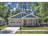 Charming home with a welcoming front porch, well-manicured lawn, and two-car garage at 151 Cobble Ridge Dr, Pittsboro, NC 27312