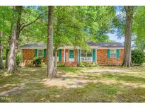 Charming brick home with mature trees, shutters, and covered front porch at 1703 Keogh St, Burlington, NC 27215