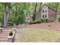 Charming brick and siding home with mature trees and brick stairs leading to the front door at 201 Red Bud Ln, Chapel Hill, NC 27514