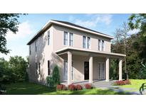 Two-story home with covered porch, neutral siding, and beautifully landscaped front yard at 203 E Winmore Ave, Chapel Hill, NC 27516