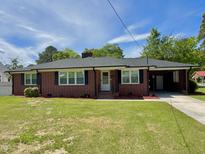 Charming brick home with a well-maintained lawn and blue sky at 213 N Brevard St, Selma, NC 27576
