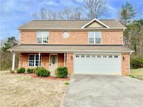 Charming two-story brick home with a well-manicured lawn and attached two-car garage at 2193 Boyd Creek Dr, Graham, NC 27253