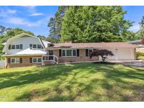 Charming two-story brick home with manicured lawn, attached garage, and beautiful mature trees at 2300 Radius Cir, Sanford, NC 27330