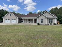Charming single-story home with a two-car garage, front porch, well-manicured lawn, and inviting curb appeal at 2483 Mcneill Hobbs Rd, Bunnlevel, NC 28323