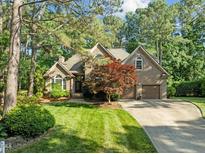 Beautiful two-story brick home featuring a well-manicured lawn and attached two-car garage at 266 Hogans Valley Way, Cary, NC 27513