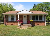 Charming brick home with covered front porch and lovely flower baskets, plus a well-manicured lawn at 2719 S Nc 87, Graham, NC 27253