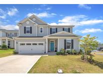Charming two-story home featuring a light gray exterior, black shutters, a two-car garage, and a manicured lawn at 3313 Brunot St, New Hill, NC 27562