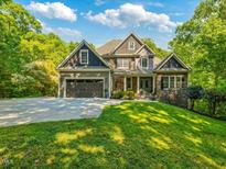 Charming home with a beautifully landscaped front yard, attached garage, and stone and wood facade at 445 Ridge Springs Dr, Chapel Hill, NC 27516
