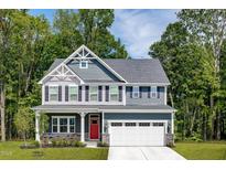 Charming two-story home featuring a red door, gray siding, and lush landscaping at 488 Freedom Trail Dr, Angier, NC 27592