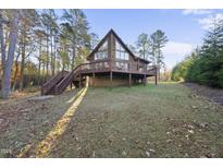 Inviting exterior of a cabin-style home with a wooden deck and natural surroundings at 50 Tyler Ct, Henderson, NC 27537