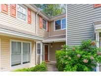 Inviting exterior of the two-story townhouse with a well-manicured lawn and attractive orange window shutters at 509 Darby Glen Ln, Durham, NC 27713