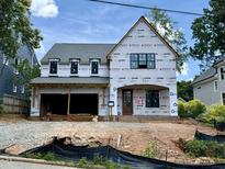 New two-story home featuring an attached two-car garage, a front door with a covered porch, and multiple windows at 521 Peebles St, Raleigh, NC 27608