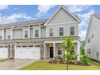 Charming two-story home featuring a stone-accented garage and inviting front porch at 646 Shelford Trl, Zebulon, NC 27597