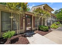 Inviting front entrance with a glass door and neutral toned exterior with tasteful landscaping at 75 Stone Hill Ct, Durham, NC 27704