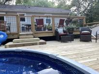 Relaxing pool deck with a wooden deck and comfortable seating, perfect for enjoying summer days at 7824 Hemlock Ct, Raleigh, NC 27615