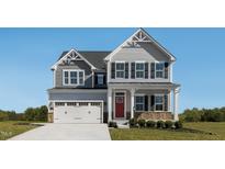Charming two-story home with a two car garage, a manicured lawn and a striking red front door at 1012 Country Pasture Cv, Wendell, NC 27591