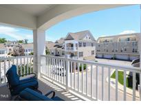 Relaxing balcony view with blue cushioned chairs and white railing overlooking neighborhood street at 10529 Sablewood Dr # 116, Raleigh, NC 27617