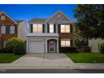 Charming two-story home featuring blue shutters, a one-car garage, and a well-maintained lawn at 107 Caraleigh Ct, Morrisville, NC 27560