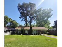 Charming single-story brick home featuring a well-manicured front yard and covered parking area at 1157 S Cambridge Cir, Rocky Mount, NC 27801
