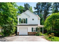 Charming two-story home with white siding, green shutters, attached garage, and mature trees at 12 Byerly Ct, Durham, NC 27713