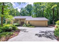 Beautiful single-story home featuring a well-manicured front yard and an attached two-car garage, surrounded by lush trees at 120 Spring Hollow Ln, Cary, NC 27518