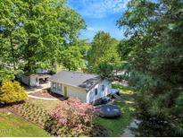 Inviting lake house showcasing lush landscaping, including vibrant azaleas, and a trampoline for outdoor fun at 135 Sagamore Dr, Louisburg, NC 27549