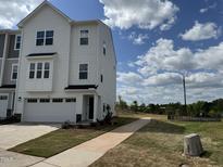 Beautiful two-story townhouse with white siding, attached garage, and lovely landscaping at 2118 Terrawood Dr, Durham, NC 27703