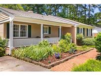 Charming home featuring a lovely front porch, well-manicured landscaping, and brick walkway at 2143 Ridge Rd, Raleigh, NC 27607