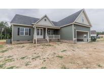 Charming single-story home featuring a covered porch, attached garage, and well-maintained siding at 25 Sanders Farm Dr, Smithfield, NC 27577