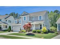 Charming two-story home with a well-manicured lawn, attached garage, and covered front porch at 2848 Angelica Rose Way, Apex, NC 27502
