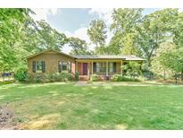 Charming brick home featuring a well-manicured front lawn and inviting front porch at 308 Rainbow Dr, Carrboro, NC 27510
