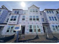 New construction townhome featuring multiple windows awaiting finishing touches, offering bright living spaces at 323 Chesapeake Cmns St # 104, Garner, NC 27529