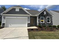 Charming home featuring a two-car garage, stone accents, light gray siding and well-maintained landscaping at 38 Gander Dr, Benson, NC 27504