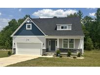 Charming new construction featuring stone accents, a covered entryway, and a two-car garage at 42 Hemming Ct, Cameron, NC 28326