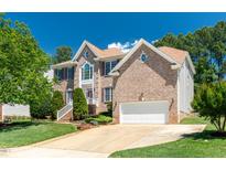 Charming two-story brick home with a well-manicured lawn and attached two-car garage at 4404 Triland Way, Cary, NC 27518