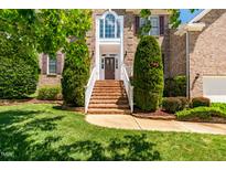Beautiful brick home featuring a landscaped front yard and inviting brick stairs leading to the front door at 4404 Triland Way, Cary, NC 27518