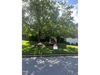 A charming home with a lush, green lawn and mature trees in a tranquil residential neighborhood at 4404 Triland Way, Cary, NC 27518