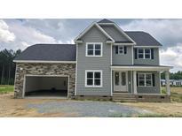 Charming two-story home featuring stone accents, neutral siding, double-hung windows, and an attached two-car garage at 48 Sanders Farm Dr, Smithfield, NC 27577