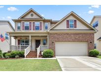 Inviting two-story home featuring a covered front porch, brick facade, and well-maintained landscaping at 508 Minerva Dale Dr, Fuquay Varina, NC 27526