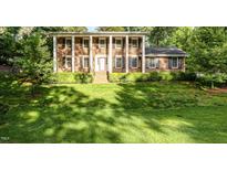 Classic brick home featuring stately white columns and a well-manicured front lawn at 5513 Parkwood Dr, Raleigh, NC 27612