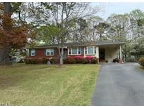Charming single-story home with brick facade, covered parking, and mature landscaping at 5517 Spring Rd, Raleigh, NC 27603
