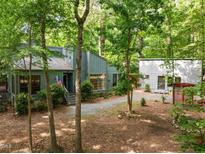 Charming home with well-maintained landscaping, gravel driveway and American flag at 61 Stone Ledge, Pittsboro, NC 27312