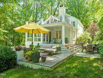 Charming backyard patio with a seating area, lush greenery, and a sun umbrella perfect for outdoor relaxation at 612 Swift Ave, Durham, NC 27701