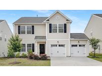 Charming two-story home featuring a two-car garage, black shutters, and well-maintained landscaping at 69 Curling Creek Dr # I286, Clayton, NC 27527
