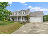 Charming home featuring a spacious front porch, attached two-car garage, and well-manicured lawn at 7805 Tuscan Ridge Dr, Wendell, NC 27591
