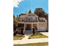 Charming two-story home featuring a welcoming front porch, well-manicured lawn, and attached two car garage at 102 Kipling Dr, Oxford, NC 27565